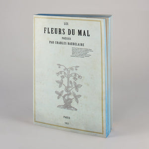 Notebook con copertina Les Fleurs du Mal e laterali azzurri.